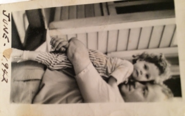 Judith as a child being held in dads arms