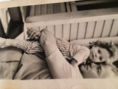 Judith as a child being held in dads arms