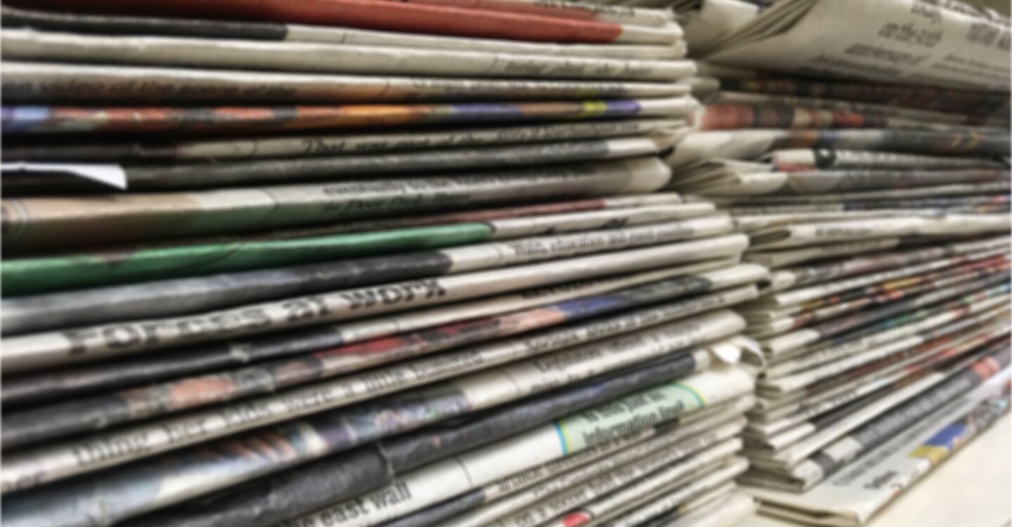 stacks of newspapers on a shelf