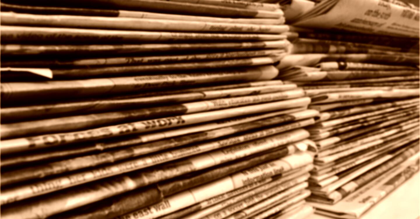 stacks of newspapers on a shelf